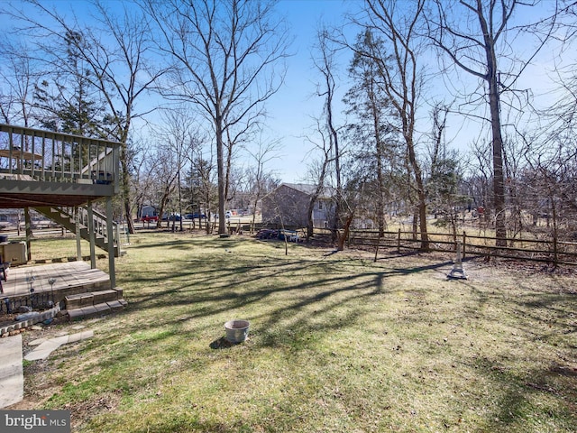 view of yard featuring stairs, fence, and a wooden deck