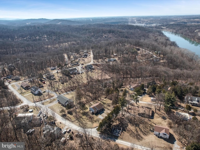 drone / aerial view featuring a wooded view and a water and mountain view