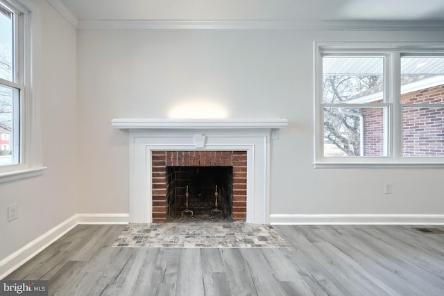 room details with visible vents, ornamental molding, a brick fireplace, wood finished floors, and baseboards