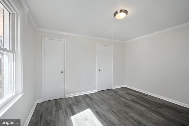 spare room with baseboards, dark wood-type flooring, and crown molding