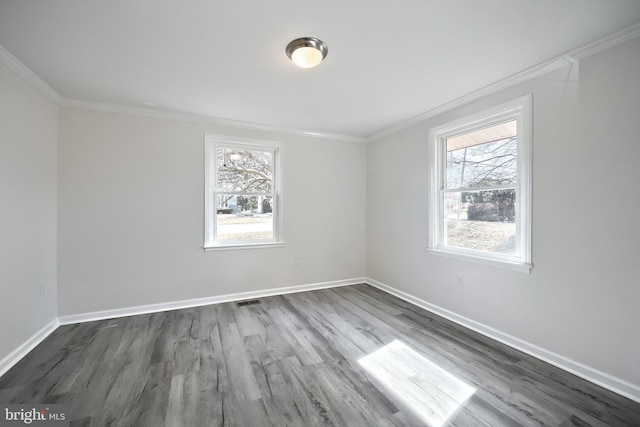 unfurnished room with a wealth of natural light, crown molding, and baseboards