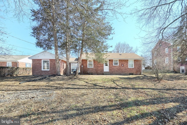 view of front facade featuring brick siding, crawl space, and a front yard