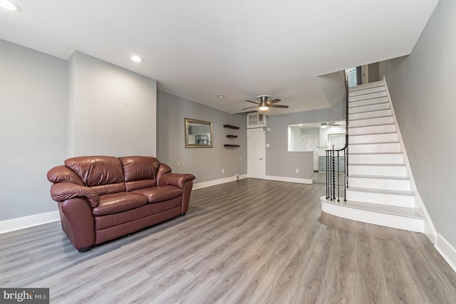 living area with stairs, wood finished floors, and baseboards