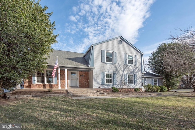 view of front facade featuring a shingled roof, brick siding, and a front lawn