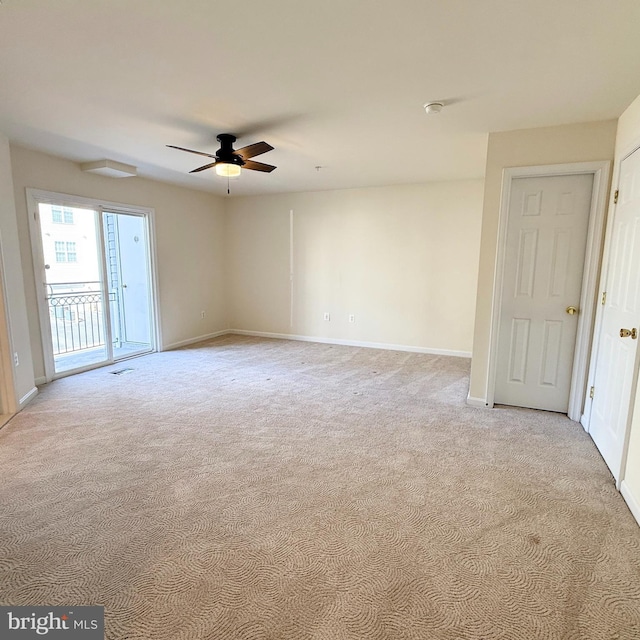 empty room with a ceiling fan, light colored carpet, and baseboards