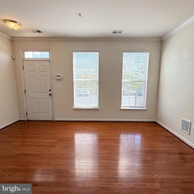 entrance foyer featuring ornamental molding, visible vents, baseboards, and wood finished floors