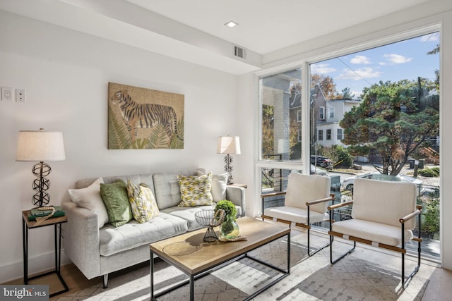 living room featuring visible vents, baseboards, and wood finished floors