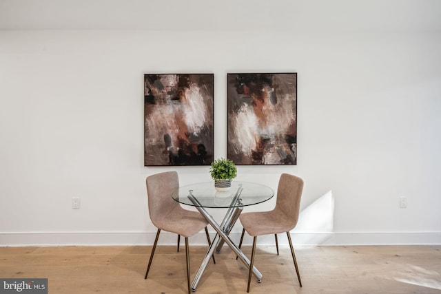 dining space with baseboards and wood finished floors