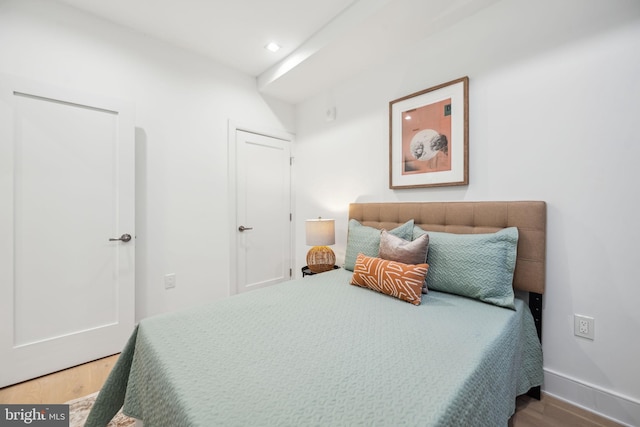 bedroom featuring baseboards, wood finished floors, and recessed lighting