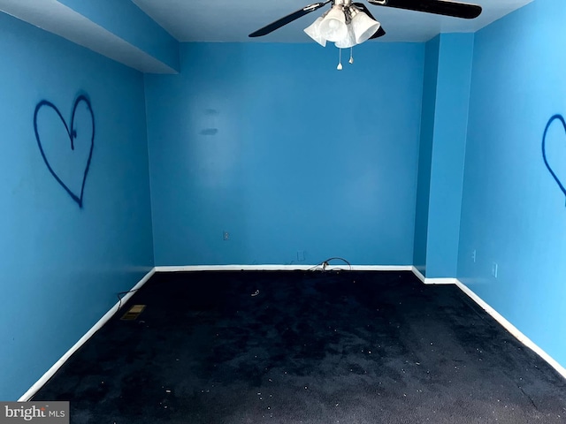 unfurnished room featuring a ceiling fan and baseboards