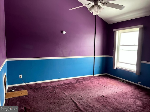 carpeted spare room with visible vents, baseboards, and ceiling fan