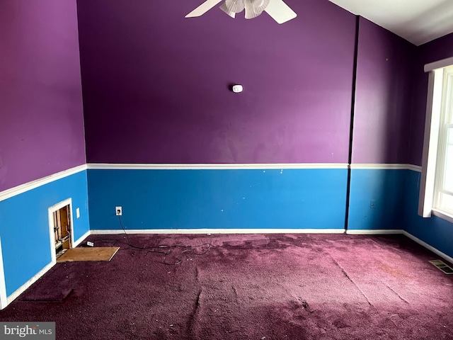 carpeted spare room featuring a ceiling fan, visible vents, and baseboards