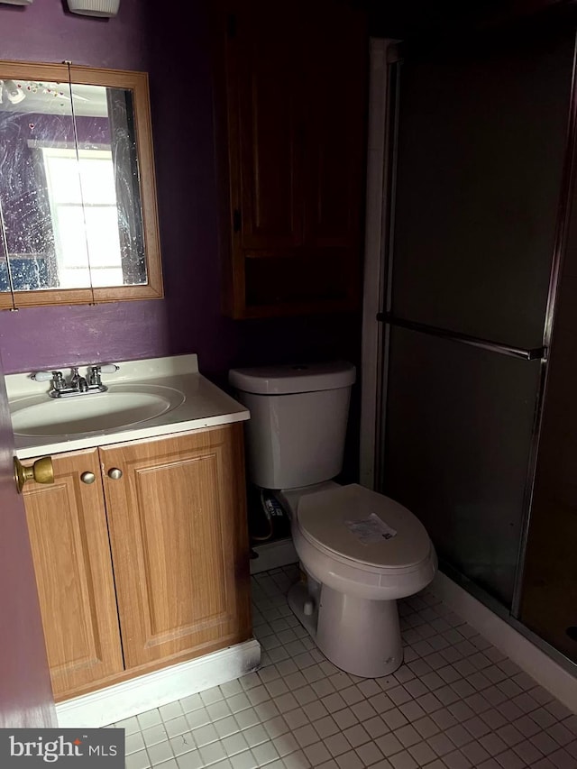 bathroom featuring a stall shower, tile patterned flooring, vanity, and toilet