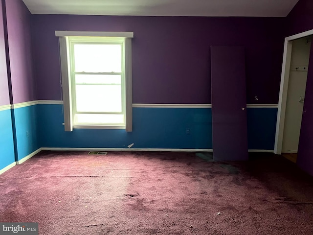 unfurnished room with carpet floors, baseboards, and visible vents