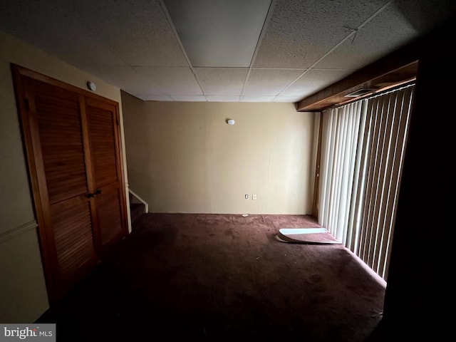 interior space with stairs, carpet flooring, and a paneled ceiling