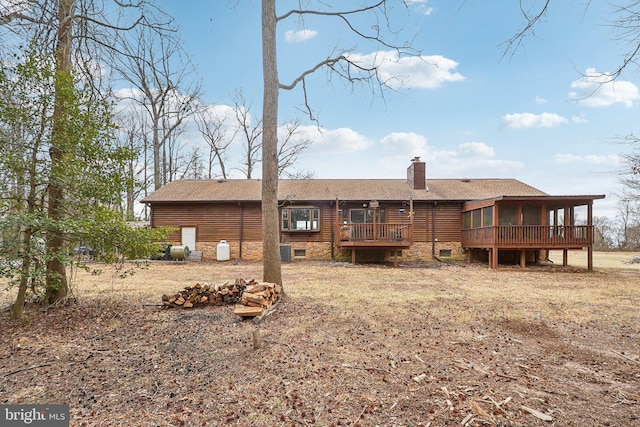 back of house with a sunroom and a chimney