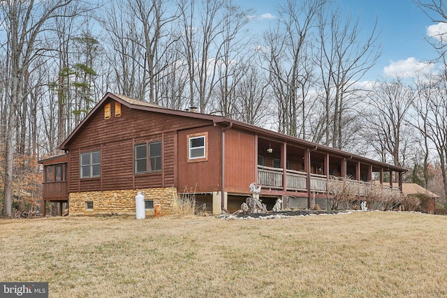 view of property exterior featuring a porch, stone siding, and a lawn