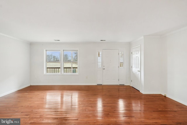 foyer entrance featuring ornamental molding, baseboards, and hardwood / wood-style floors