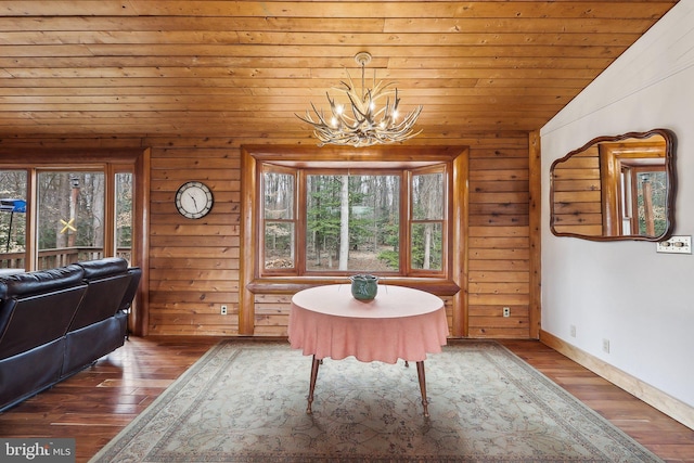 unfurnished dining area with dark wood-style flooring, an inviting chandelier, vaulted ceiling, wooden ceiling, and baseboards