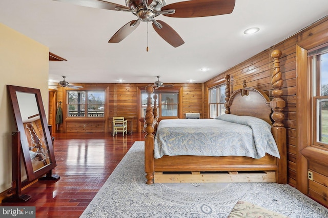 bedroom featuring recessed lighting, dark wood-style flooring, and wooden walls