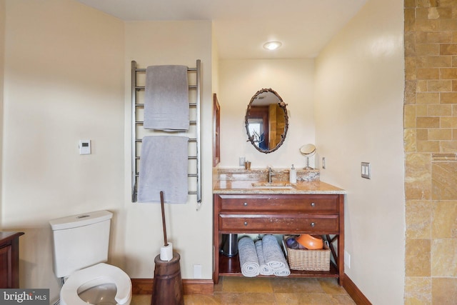 full bathroom with toilet, baseboards, and vanity