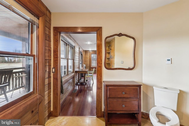 corridor with wood finished floors and wooden walls