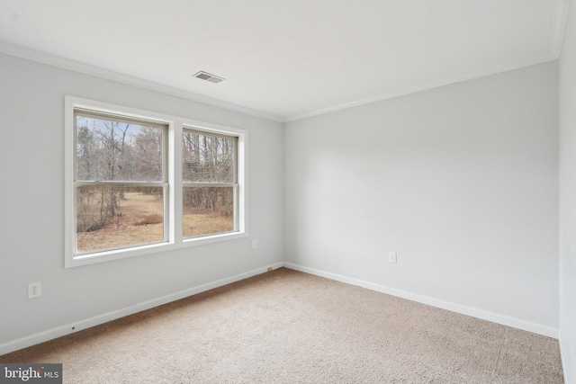 unfurnished room with ornamental molding, carpet, visible vents, and baseboards