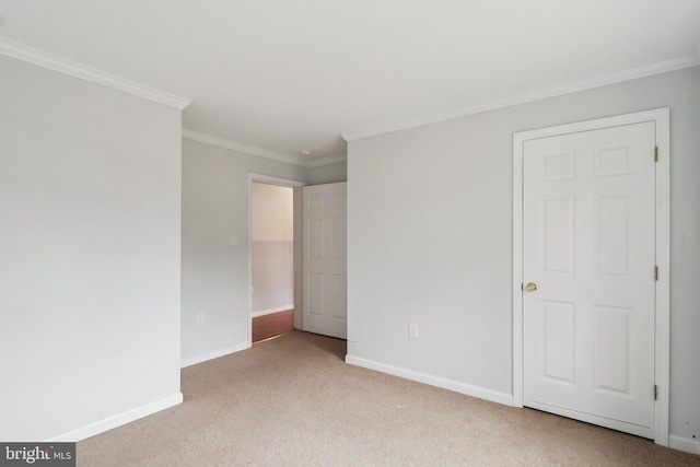 unfurnished bedroom with ornamental molding, carpet flooring, and baseboards