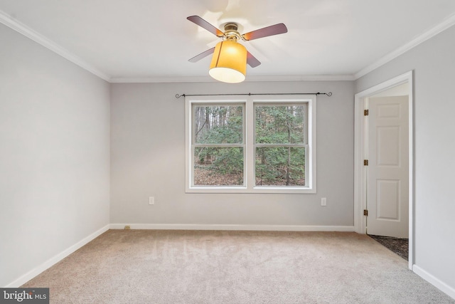 empty room with carpet floors, baseboards, ornamental molding, and ceiling fan