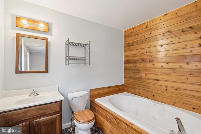 full bath featuring toilet, vanity, and a whirlpool tub