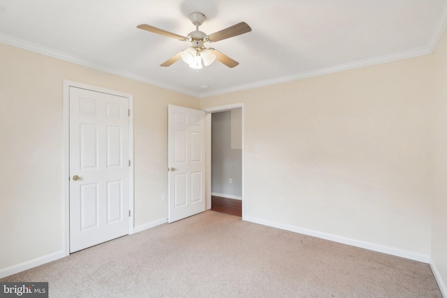 unfurnished bedroom with carpet, crown molding, and baseboards