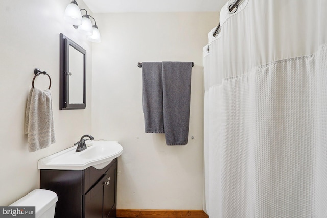 bathroom with a shower with shower curtain, vanity, and toilet