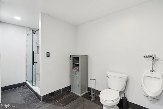 bathroom with toilet, a shower stall, and baseboards