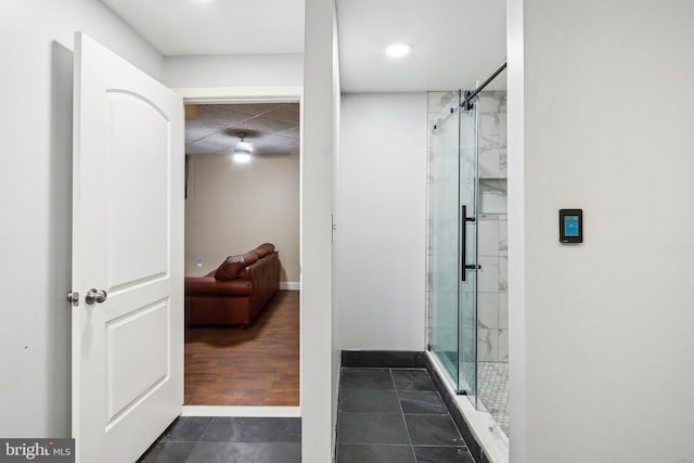 bathroom featuring a stall shower, tile patterned flooring, and baseboards