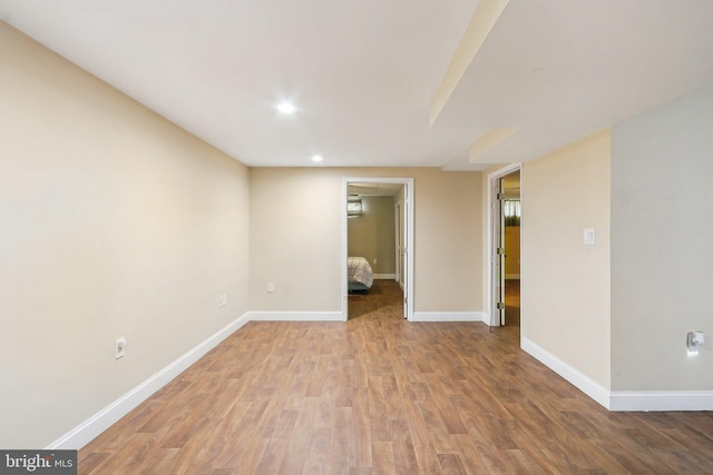 empty room featuring recessed lighting, baseboards, and wood finished floors