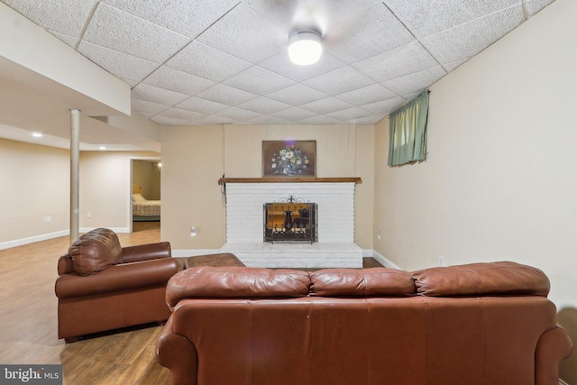 living area with a fireplace, baseboards, and wood finished floors