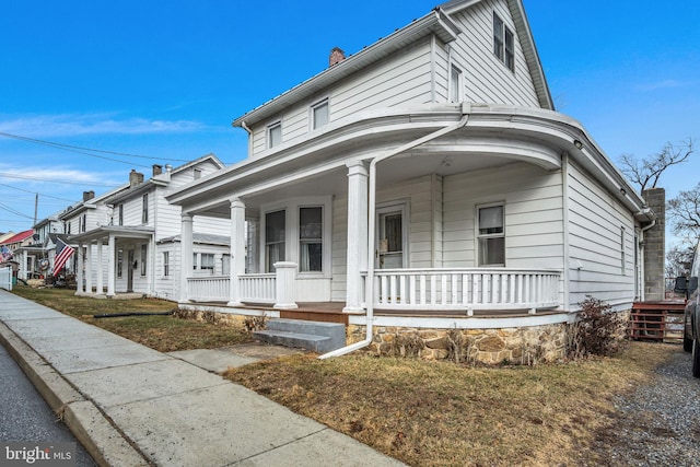 view of front of home with covered porch and a chimney