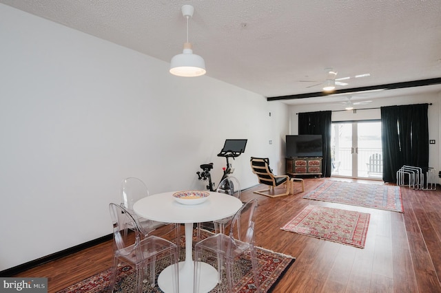 dining room featuring french doors, a ceiling fan, a textured ceiling, wood finished floors, and baseboards