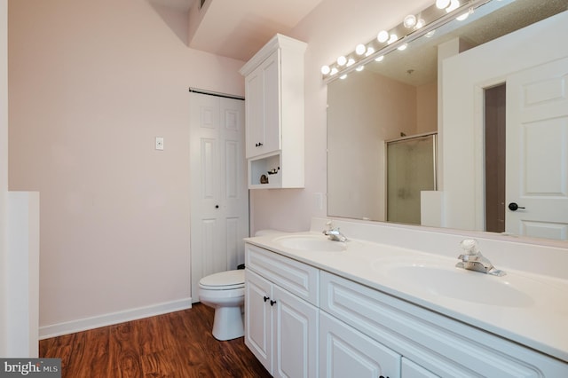 full bath with wood finished floors, a stall shower, a sink, and baseboards