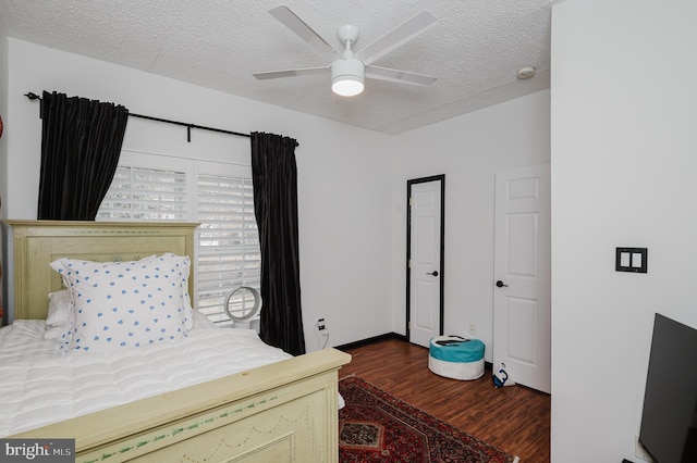 bedroom featuring a ceiling fan, a textured ceiling, baseboards, and wood finished floors