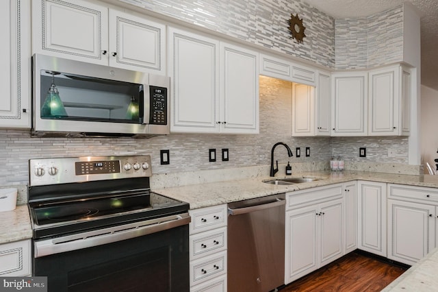 kitchen with stainless steel appliances, white cabinets, and a sink