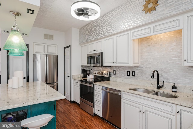 kitchen featuring stainless steel appliances, visible vents, a sink, and white cabinetry