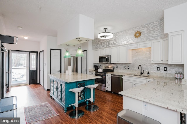 kitchen featuring dark wood finished floors, open shelves, stainless steel appliances, white cabinets, and a sink