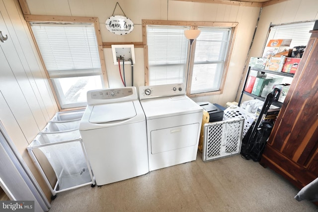 laundry area featuring light carpet, laundry area, wooden walls, and washer and dryer