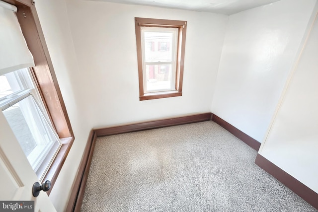 unfurnished room featuring carpet and baseboards