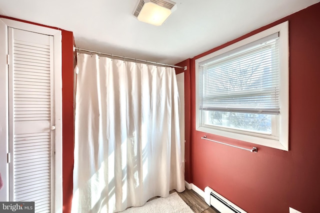 bathroom featuring a shower with curtain, a baseboard radiator, and visible vents