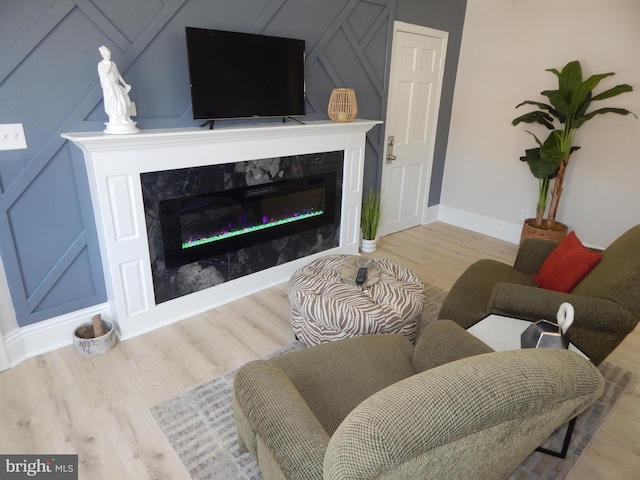 living room with a fireplace, wood finished floors, and baseboards