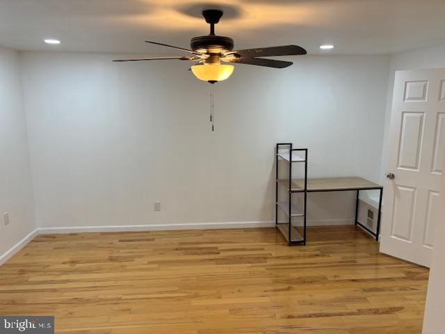 empty room with light wood-type flooring, baseboards, and recessed lighting