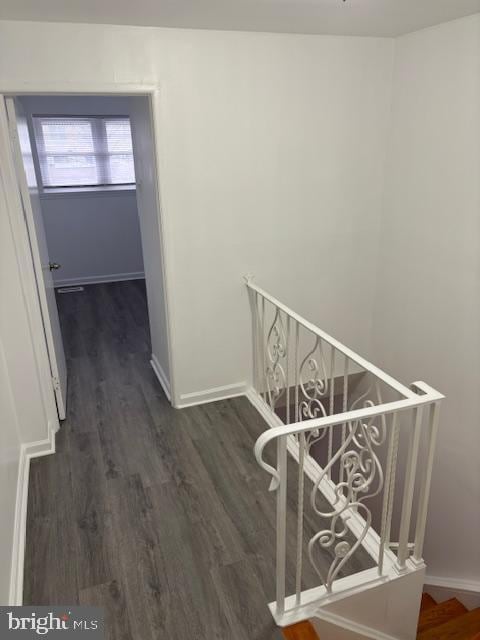 hall featuring stairway, baseboards, and wood finished floors