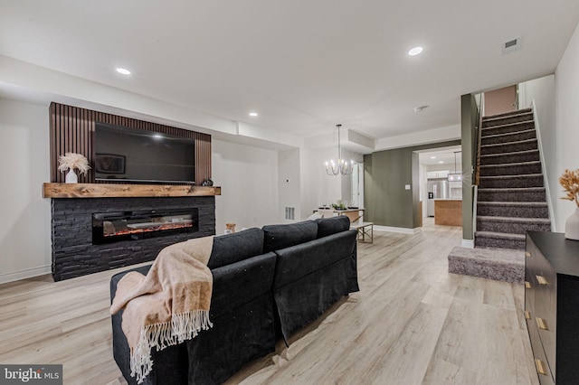 living room with wood finished floors, visible vents, baseboards, stairway, and a glass covered fireplace